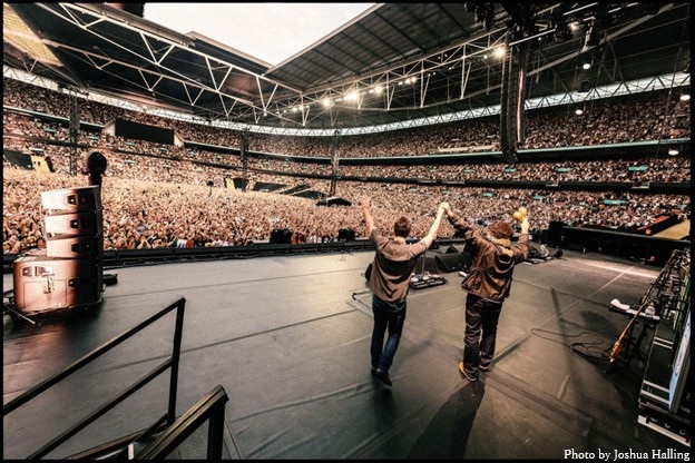 OASIS、チャリティ・アルバム『Help(2)』に収録された再結成ツアーのロンドン ウェンブリー・スタジアム公演「Acquiesce」ライヴ音源を配信リリース